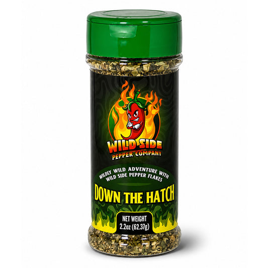 A clear plastic spice jar with a green lid and a black label featuring the Wild Side Pepper Company logo and the product name 'Down The Hatch'.